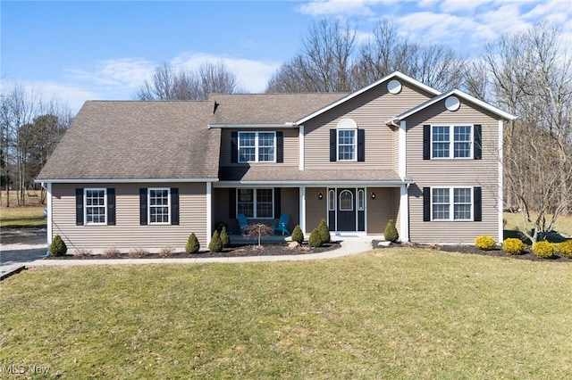 traditional-style house with a front yard, covered porch, and a shingled roof