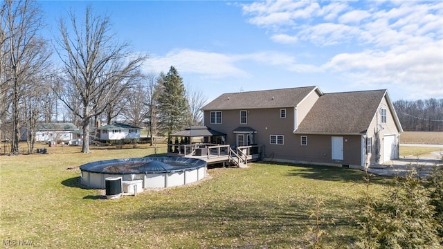 back of house with a covered pool, a gazebo, a yard, a wooden deck, and a garage