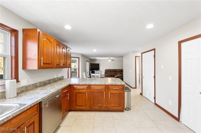 kitchen with ceiling fan, dishwasher, light tile patterned floors, brown cabinets, and a peninsula