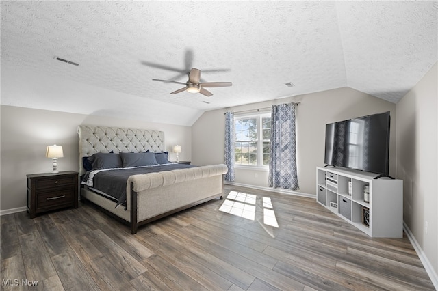 bedroom with dark wood-type flooring, baseboards, visible vents, and lofted ceiling