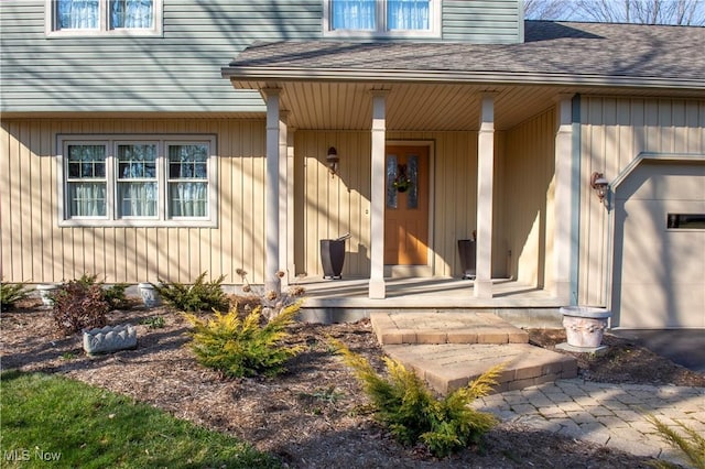 property entrance with a porch, a garage, driveway, and a shingled roof