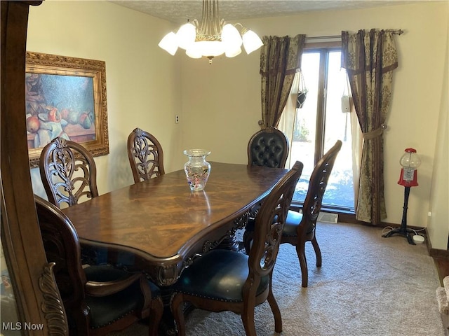 carpeted dining room with a notable chandelier, visible vents, and a textured ceiling