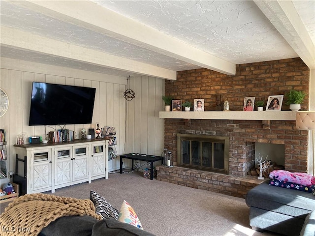 carpeted living room with beam ceiling, a brick fireplace, and a textured ceiling