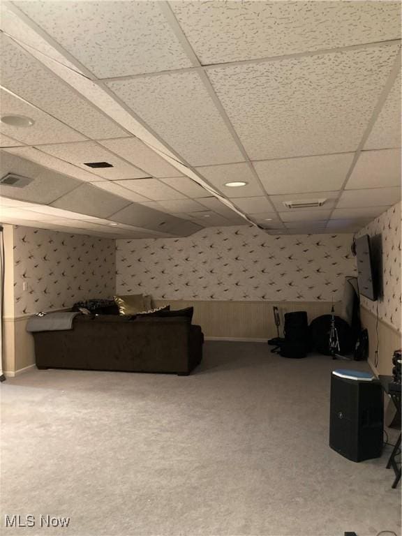 interior space with a drop ceiling, wallpapered walls, visible vents, and carpet floors