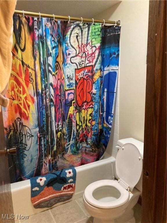 bathroom featuring shower / bath combo with shower curtain, toilet, and tile patterned flooring