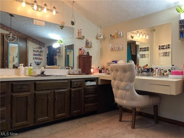 bathroom featuring a textured ceiling, vanity, and vaulted ceiling