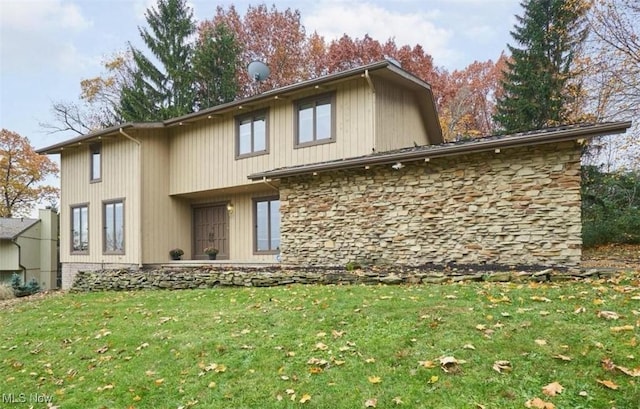 back of property featuring a yard and stone siding