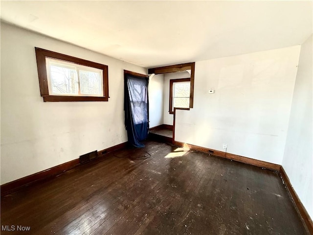 spare room featuring baseboards and hardwood / wood-style floors