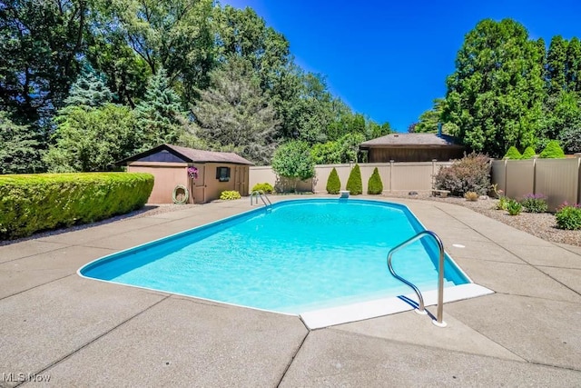 view of pool featuring an outbuilding, a fenced in pool, a patio, and a fenced backyard