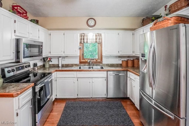 kitchen featuring a sink, appliances with stainless steel finishes, and white cabinets