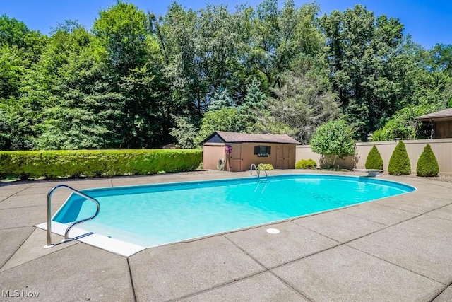 view of swimming pool featuring a patio area, a fenced in pool, an outdoor structure, and fence