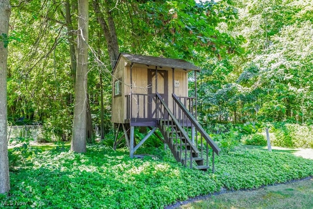 view of playground with stairway and a wooded view