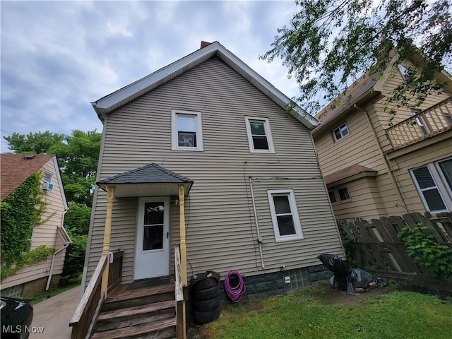 back of property with central AC unit and fence