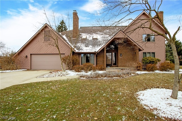 view of front of home with driveway, a chimney, a garage, a lawn, and brick siding