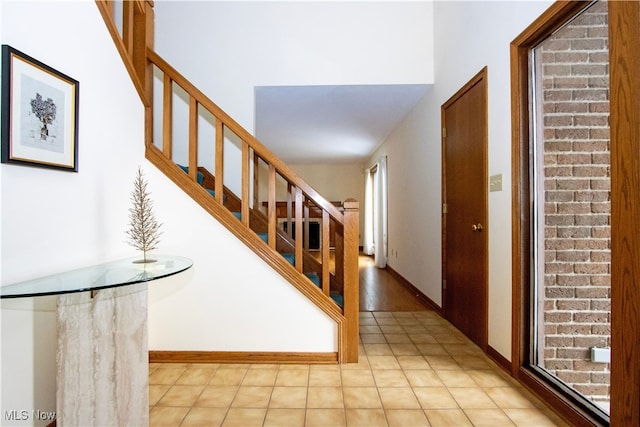 foyer featuring stairway and baseboards