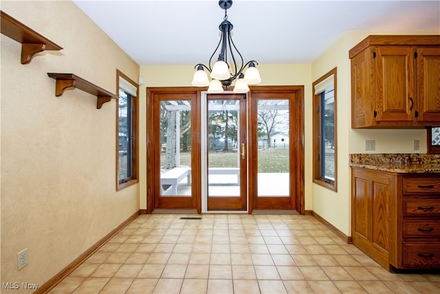 doorway with visible vents, baseboards, and a chandelier