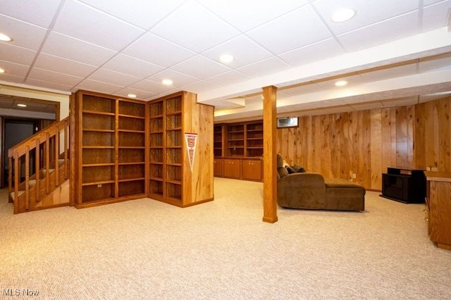 finished basement featuring recessed lighting, stairway, wood walls, and carpet flooring