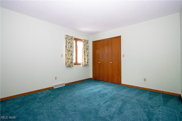 unfurnished bedroom with visible vents, carpet floors, baseboards, and a closet