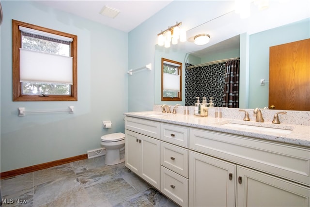 bathroom featuring a sink, visible vents, baseboards, and toilet