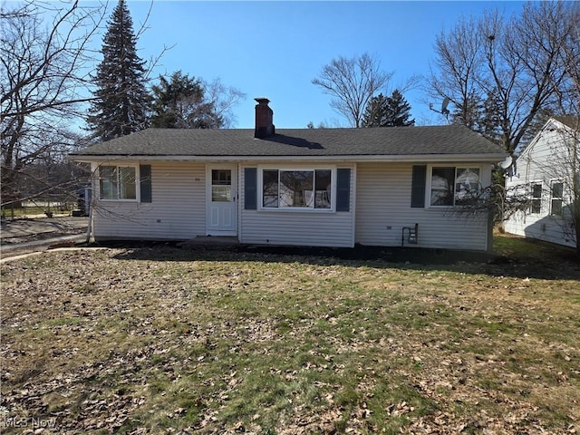 view of front of property featuring a chimney and a front yard