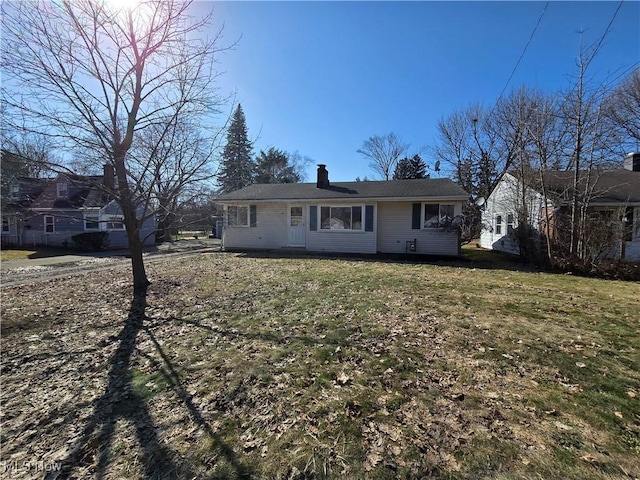 view of front of home featuring a chimney and a front yard