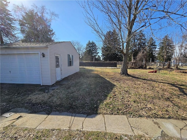 view of yard featuring an outbuilding, fence, and a garage