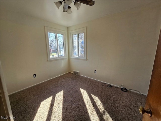 empty room with a ceiling fan, carpet, visible vents, and baseboards