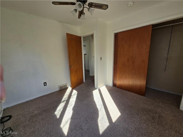 unfurnished bedroom with visible vents, carpet, a closet, and ceiling fan