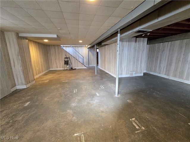 finished basement with baseboards and a paneled ceiling