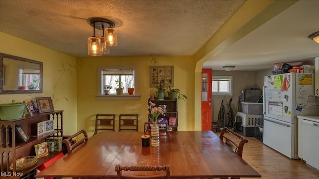 dining space featuring a textured ceiling and wood finished floors