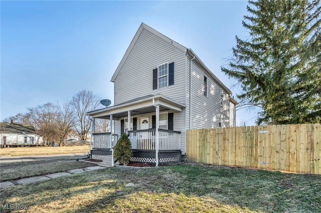 view of front of property featuring a porch, a front yard, and fence