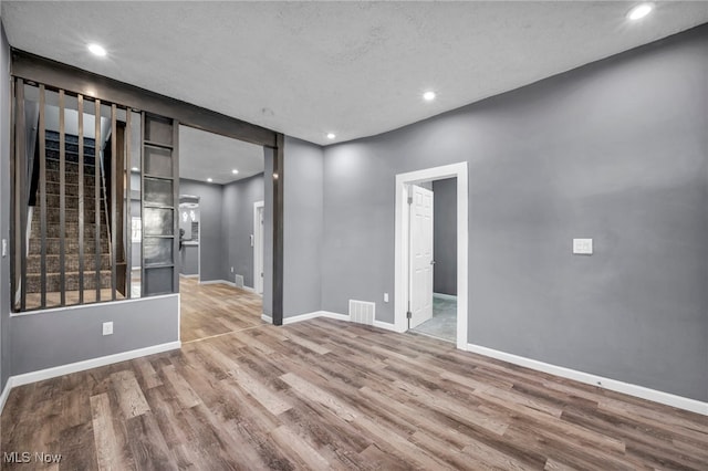 spare room with visible vents, baseboards, and wood finished floors