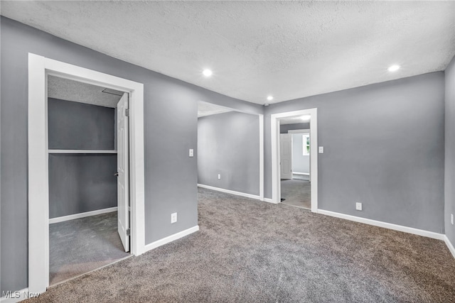 unfurnished bedroom featuring recessed lighting, a textured ceiling, baseboards, and carpet