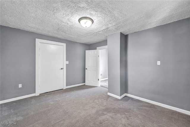 unfurnished room with baseboards, carpet, and a textured ceiling