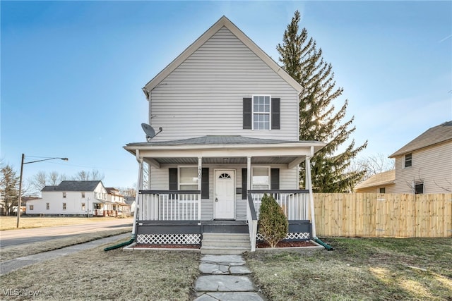 view of front of home with a porch and fence