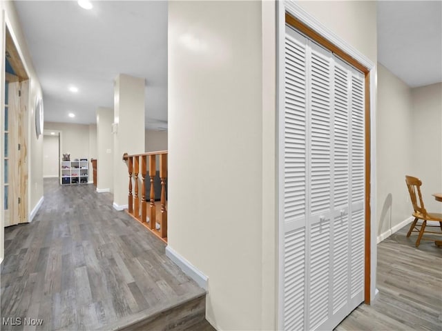 corridor with recessed lighting, baseboards, and wood finished floors