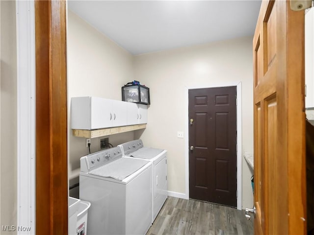 laundry room with light wood finished floors, independent washer and dryer, cabinet space, and baseboards