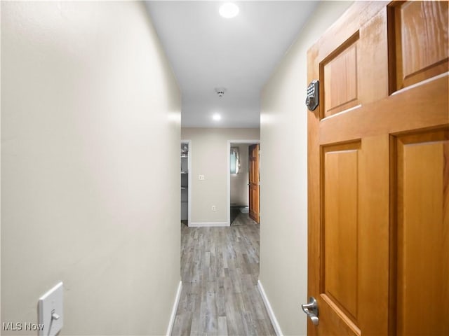 corridor with recessed lighting, baseboards, and light wood-type flooring