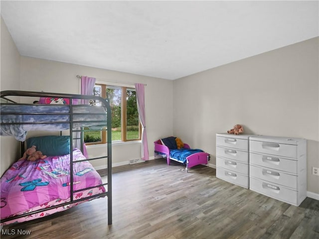 bedroom featuring visible vents, baseboards, and wood finished floors