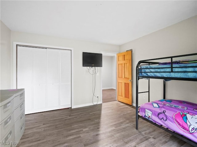 bedroom featuring a closet, baseboards, and wood finished floors