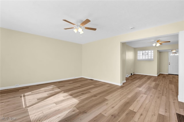 spare room featuring light wood-style flooring, baseboards, and ceiling fan