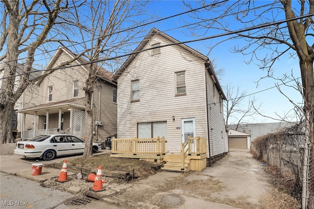 view of front facade featuring a deck, a detached garage, and an outdoor structure