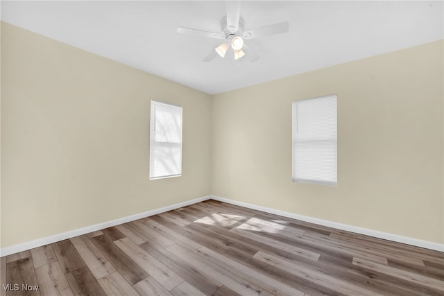 empty room featuring a ceiling fan, wood finished floors, and baseboards