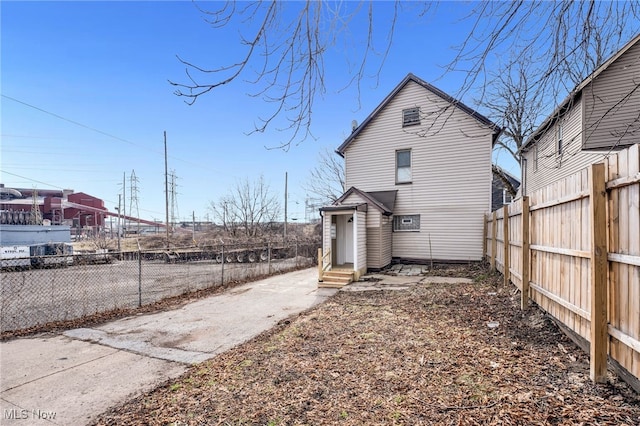 back of house with entry steps and fence