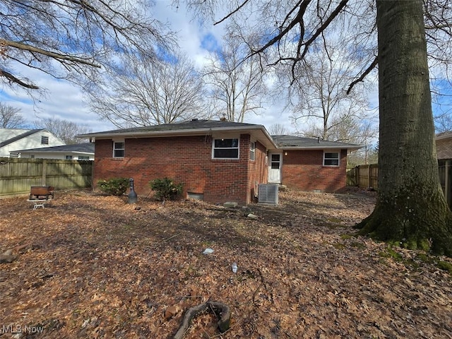 back of house featuring fence, brick siding, central AC, and crawl space