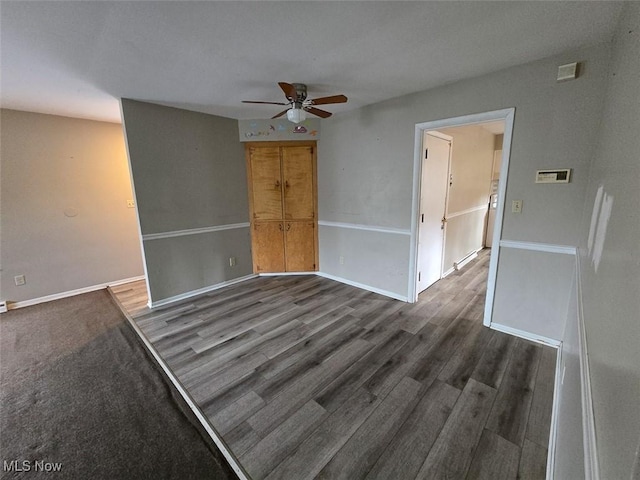 empty room with baseboards, a ceiling fan, and wood finished floors