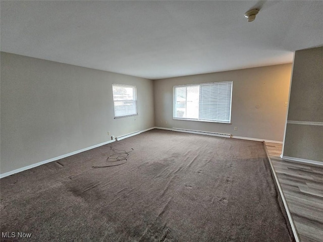 carpeted empty room featuring baseboards and baseboard heating