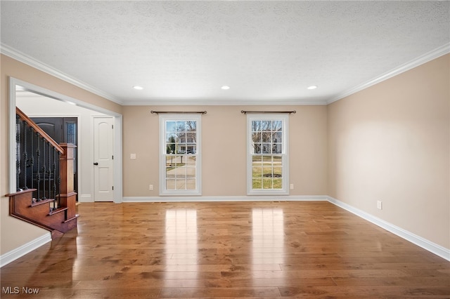 unfurnished living room with baseboards, a textured ceiling, and wood finished floors