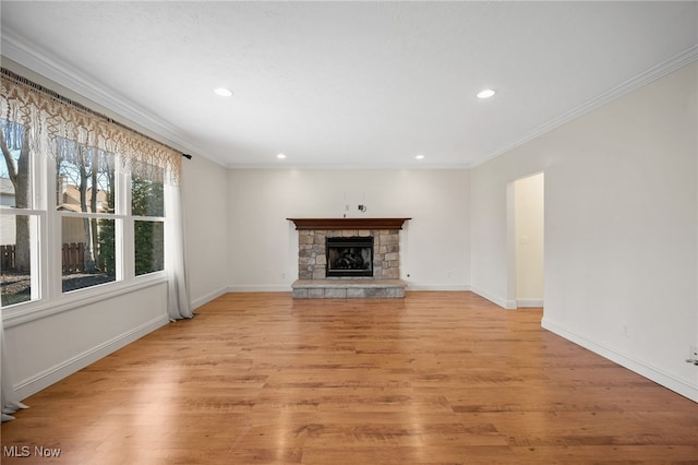 unfurnished living room featuring light wood-style flooring, a fireplace, baseboards, and ornamental molding