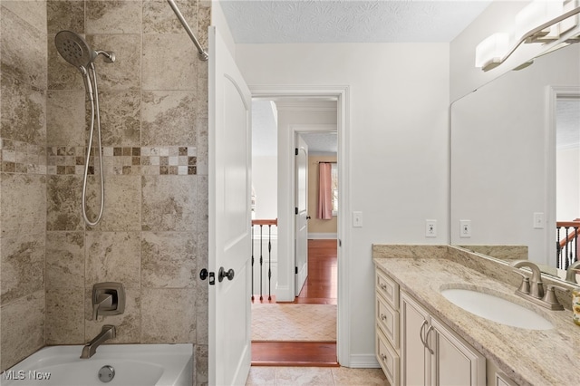 bathroom featuring vanity, baseboards, a textured ceiling, bathing tub / shower combination, and tile patterned floors